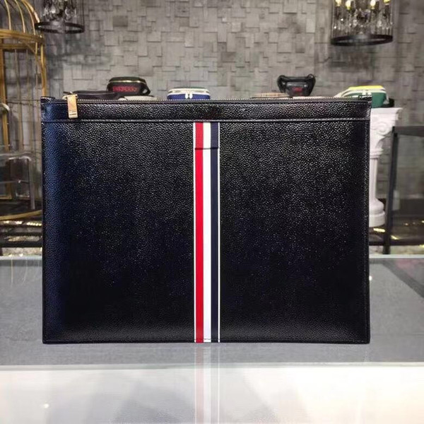 New unisex clutch. Red, white and blue ribbons are decorated with fashionable handbags and made of grain-grain leather. Striped lining, zip